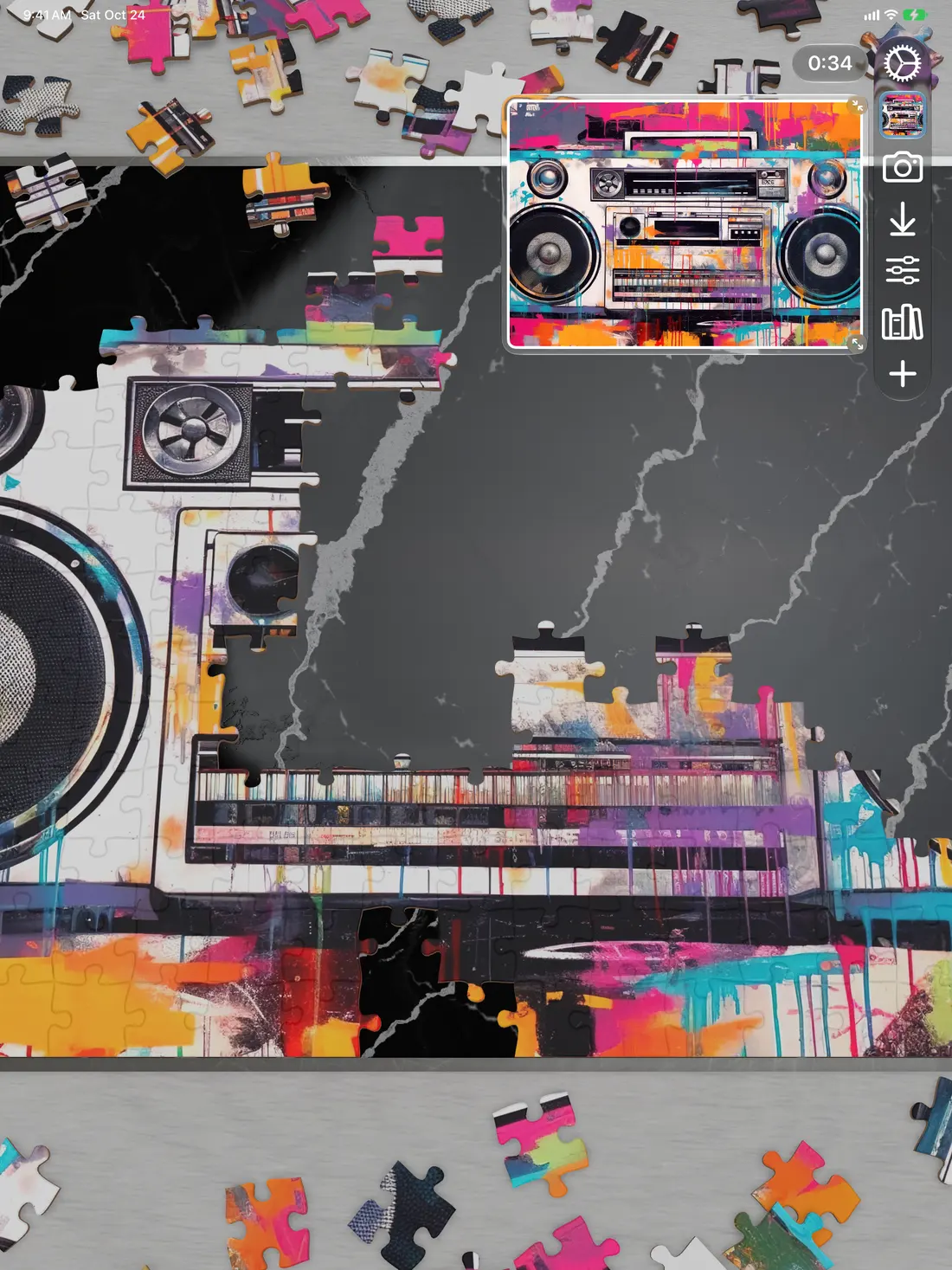 A boombox picture partly assembled on iPad, with loose pieces around the board and a small preview of the picture in the corner