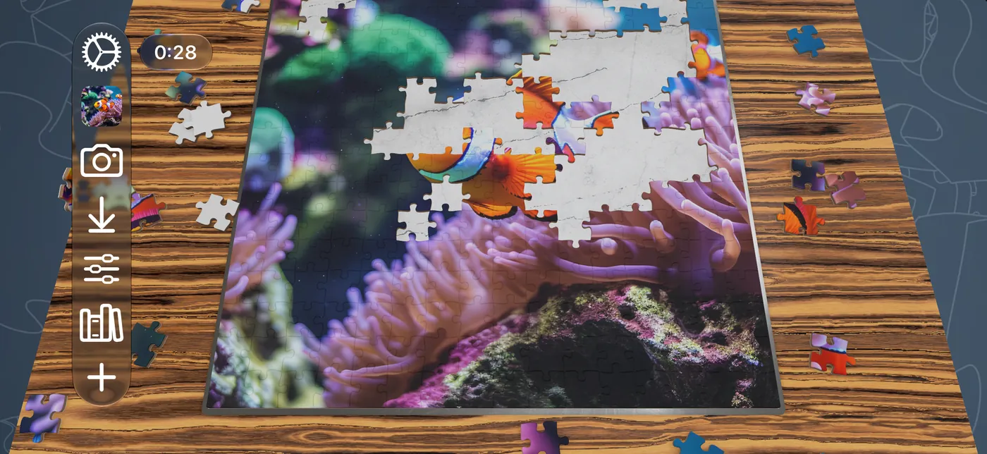 A clownfish puzzle partly assembled on iPhone in landscape, on a wood board