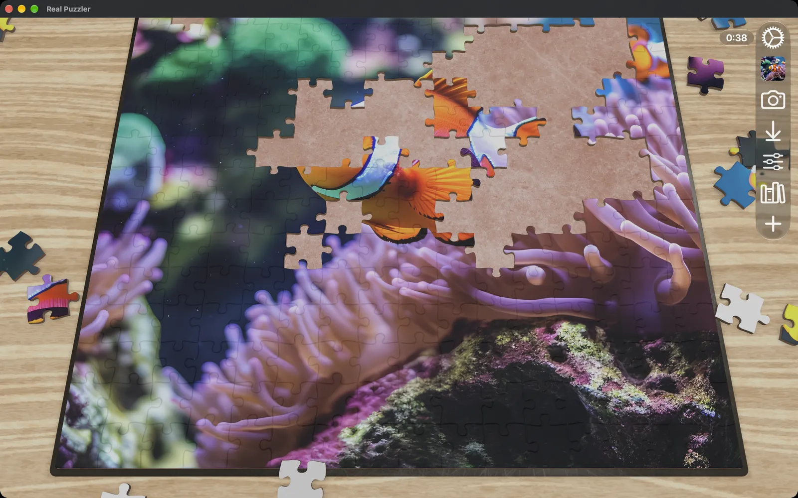 A clownfish puzzle partly assembled on a light wood board in a Mac window