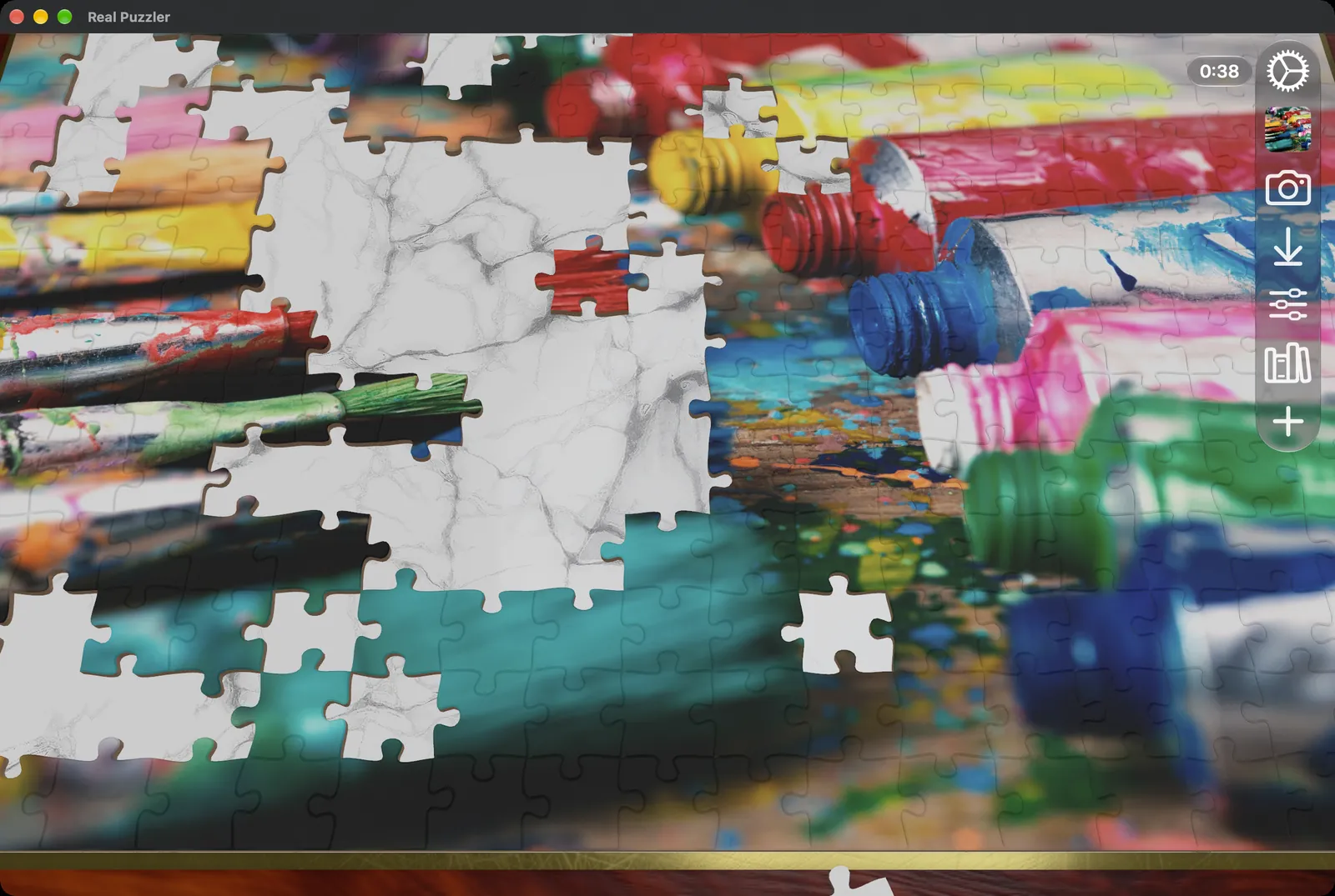 A puzzle of paint tubes partly assembled in a Mac window